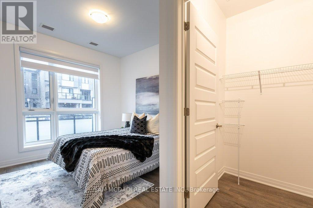A bedroom with a large bed and a view of a city through the window.