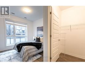 A bedroom with a large bed and a view of a city through the window.