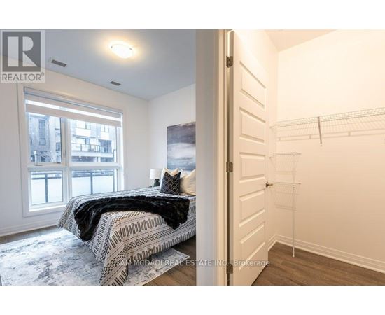 A bedroom with a large bed and a view of a city through the window.
