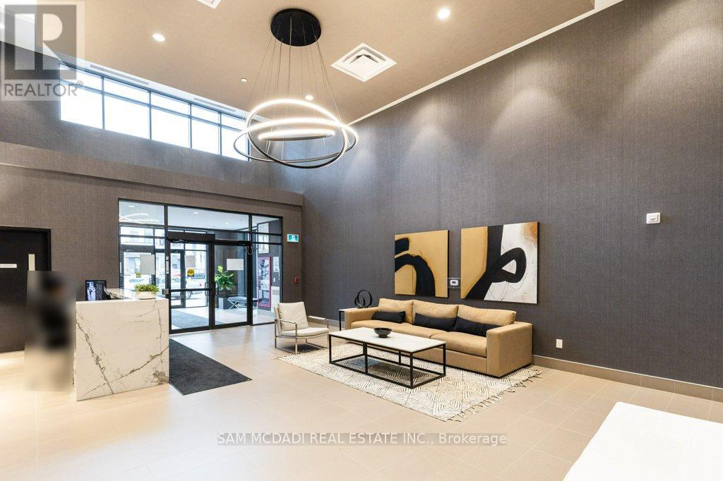 A modern living room with a large painting on the wall and a coffee table in the center.