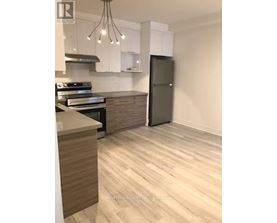 A modern kitchen with a refrigerator, stove, and cabinets.