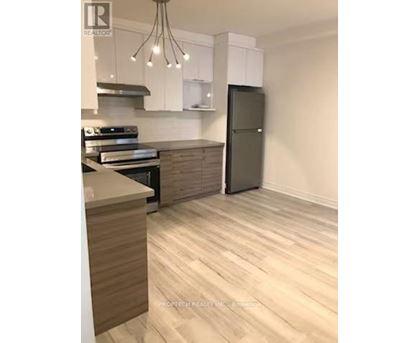 A modern kitchen with a refrigerator, stove, and cabinets.
