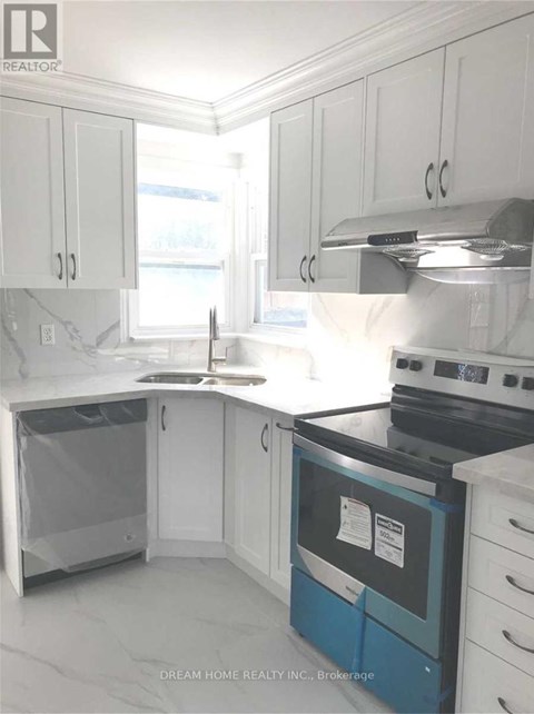 A kitchen with white cabinets and a black stove top.