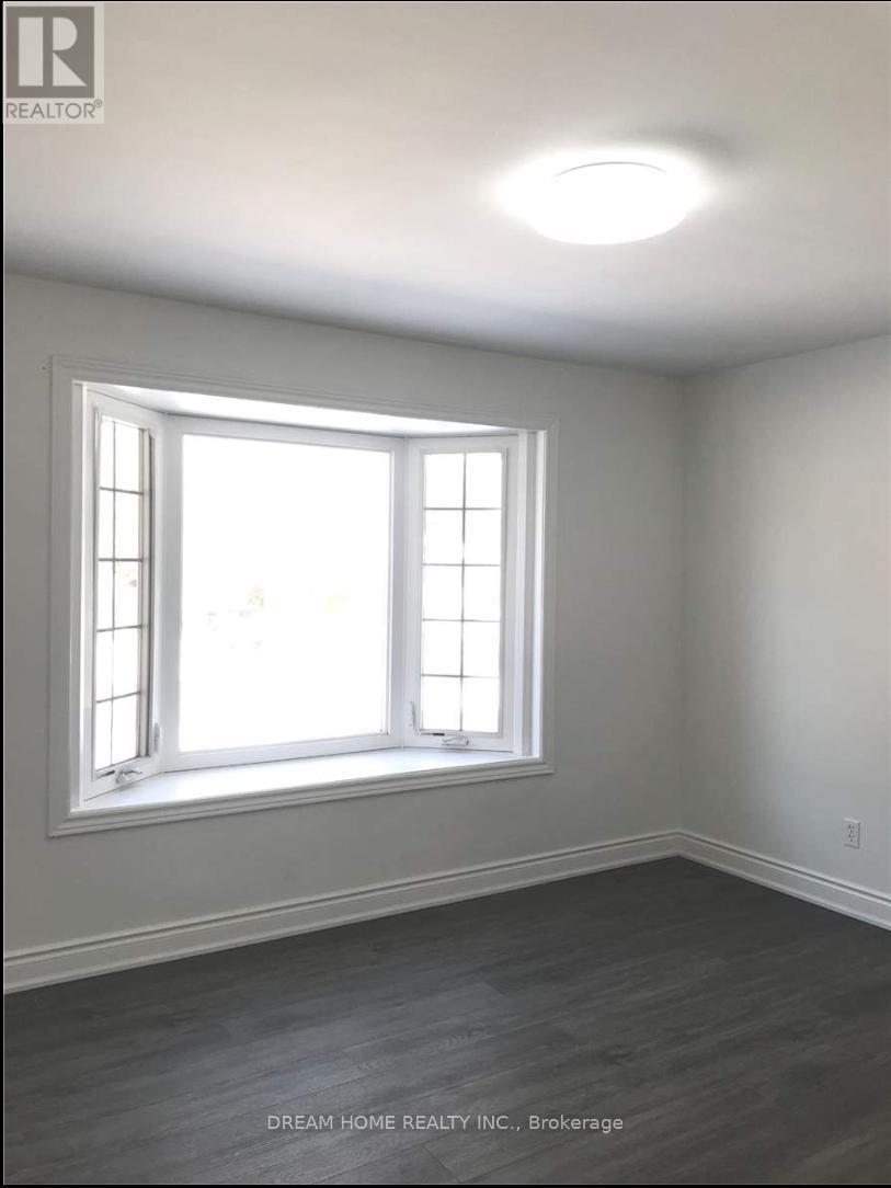 A room with a window and wooden flooring.