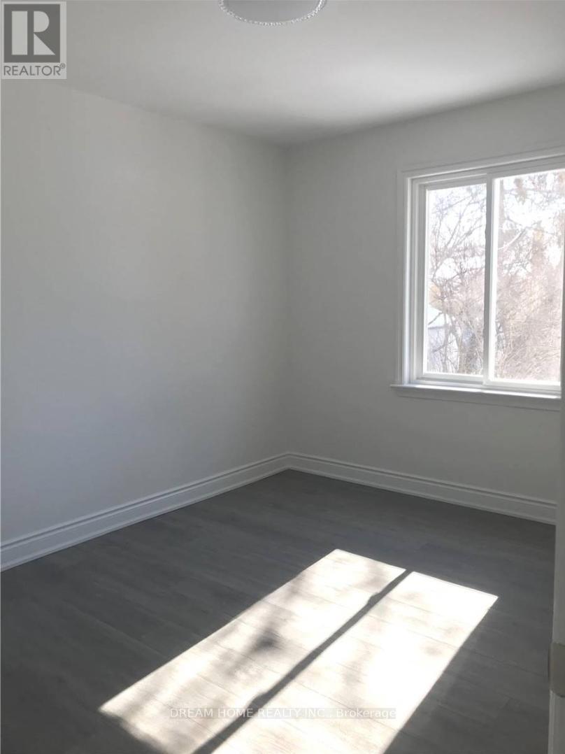 A room with a window and a grey carpet.