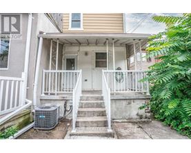 A front porch with a white railing and steps leading to a door.