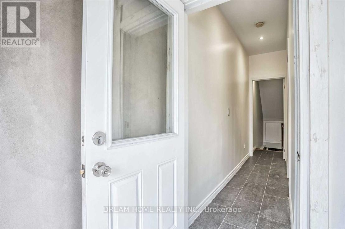 A hallway with a white door and a window.