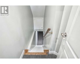 A hallway with a white door and a tiled floor.
