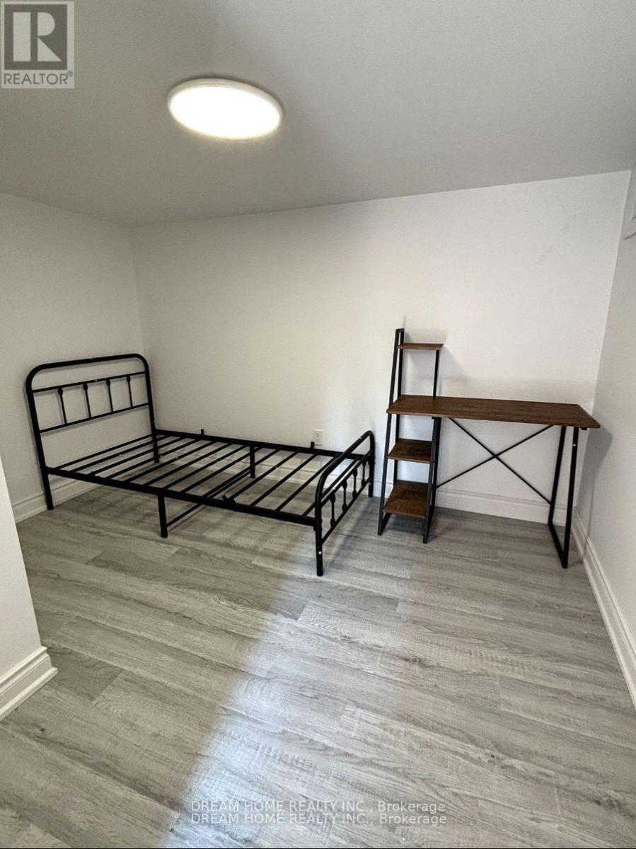 A bedroom with a bed, a chair, and a shelf.