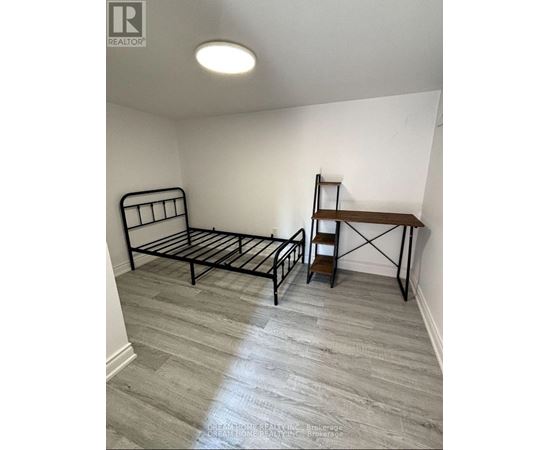 A bedroom with a bed, a chair, and a shelf.