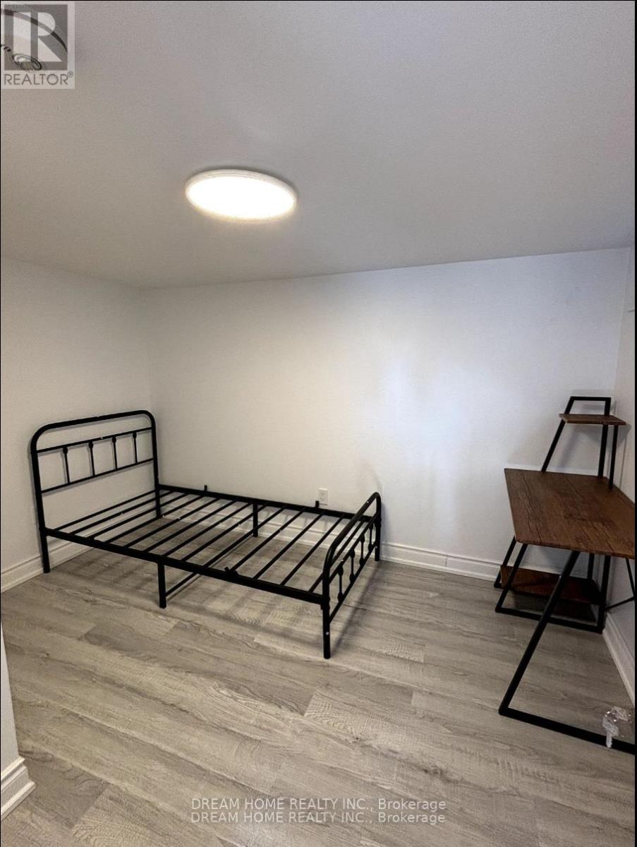A bedroom with a bed and a chair.