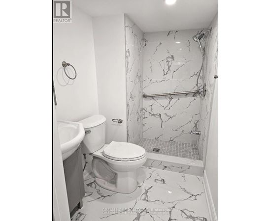 A bathroom with a marble floor and walls.