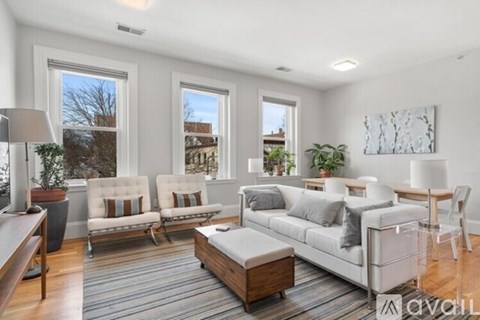 A living room with a white sofa set and a wooden coffee table.