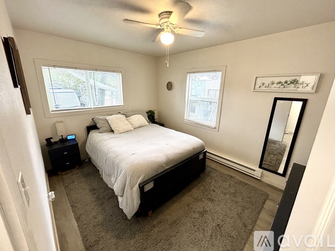 A bedroom with a bed, a ceiling fan, and a window.