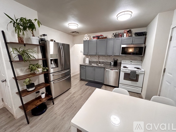 A kitchen with a white table and stainless steel appliances.