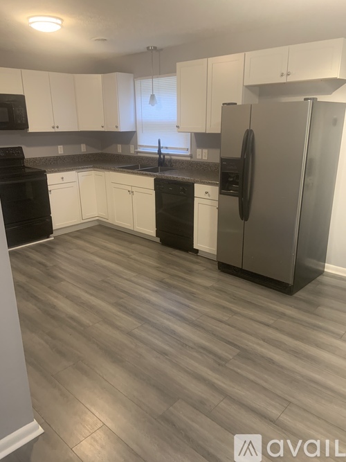 A kitchen with a refrigerator, oven, and sink.