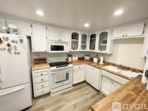 A kitchen with white cabinets and appliances.
