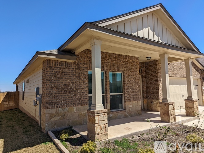 A house with a stone facade and a covered porch.