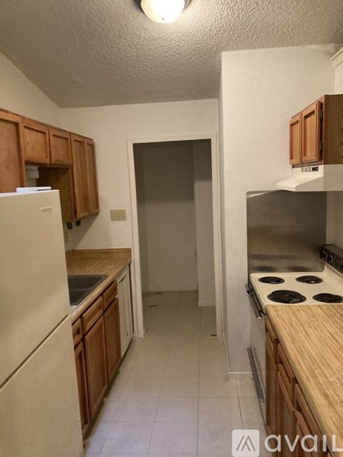 A kitchen with wooden cabinets and a white refrigerator.