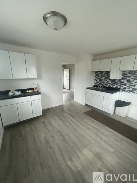 A kitchen with white cabinets and a black countertop.