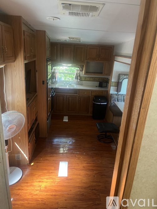 A kitchen area with wooden cabinets and a fan.