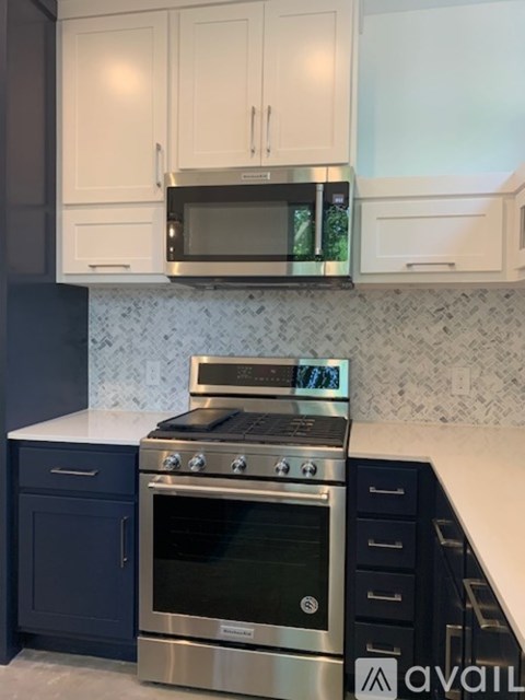 A kitchen with a stainless steel oven and microwave above it.