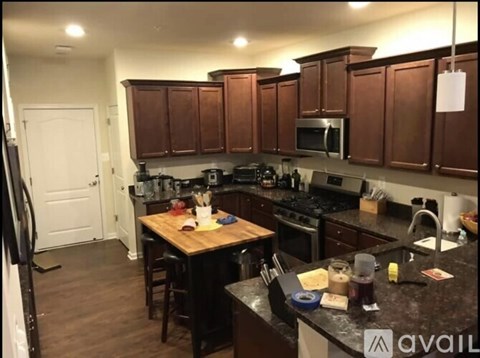 A kitchen with brown cabinets and black countertops.