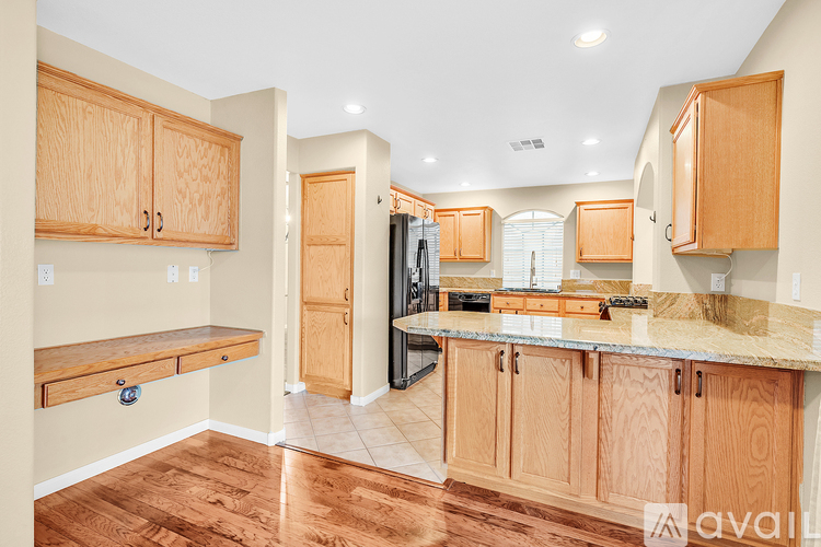 A kitchen with wooden cabinets and a marble countertop.