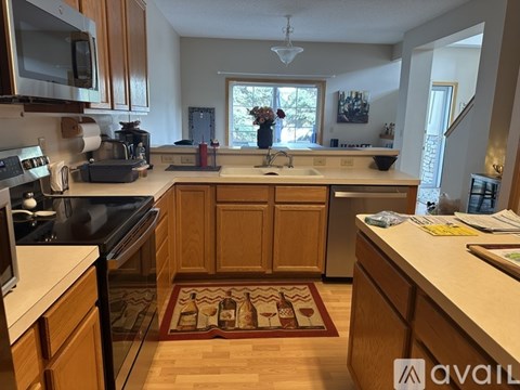 A kitchen with wooden cabinets and a rug on the floor.