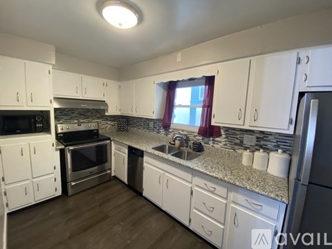 A kitchen with white cabinets and a granite countertop.