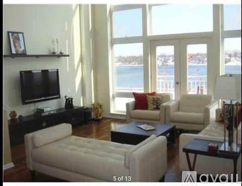 A living room with a white couch and a television.