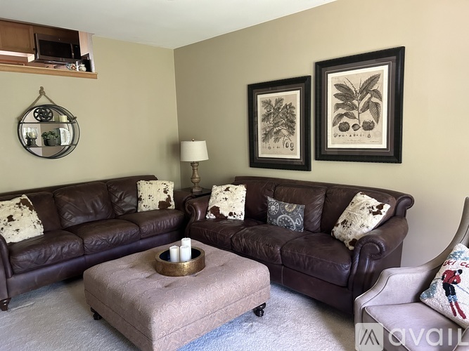 A living room with two brown leather couches and a coffee table.
