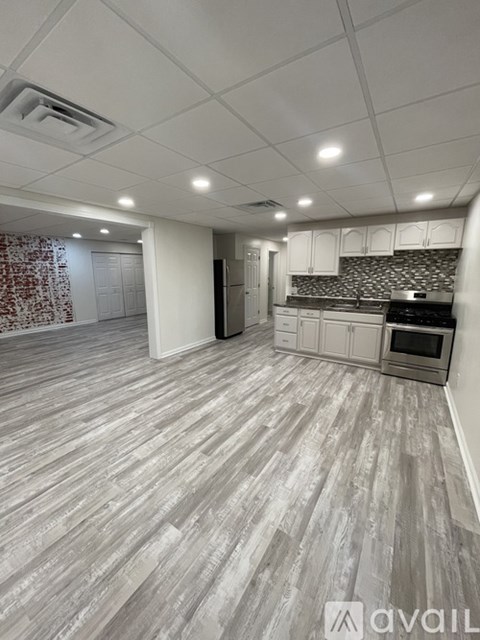 A spacious room with a grey floor and white walls.