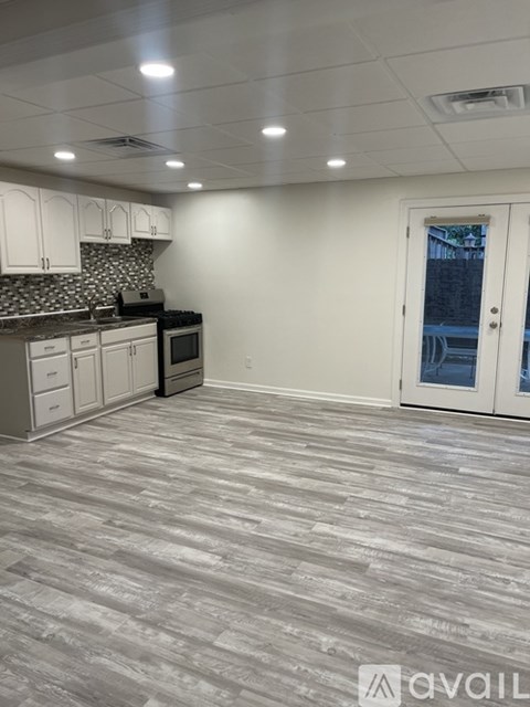 A kitchen with a grey floor and white walls.
