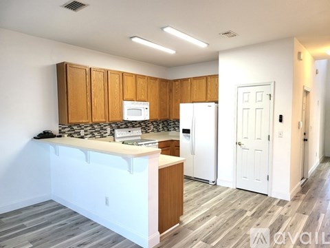 A kitchen with wooden cabinets and a white refrigerator.