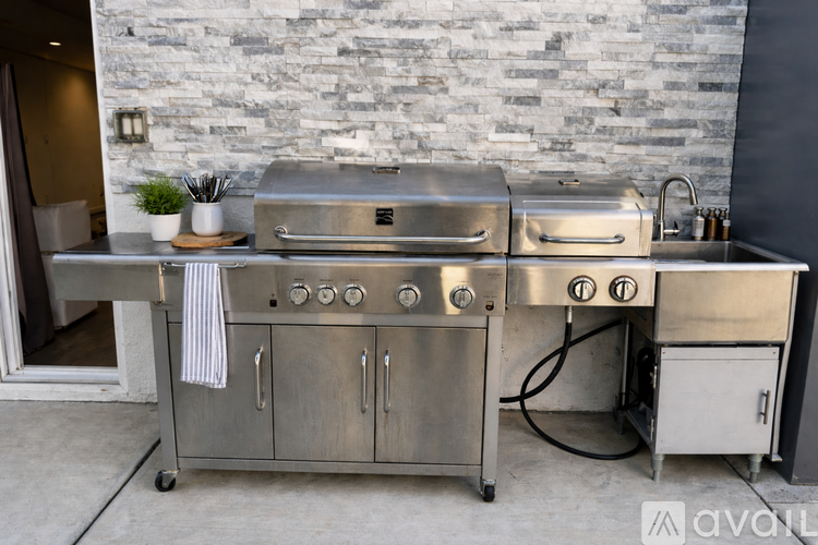 A stainless steel outdoor kitchen with a grill and sink.