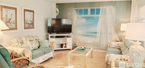 A living room with a television, sofas, and a glass table.