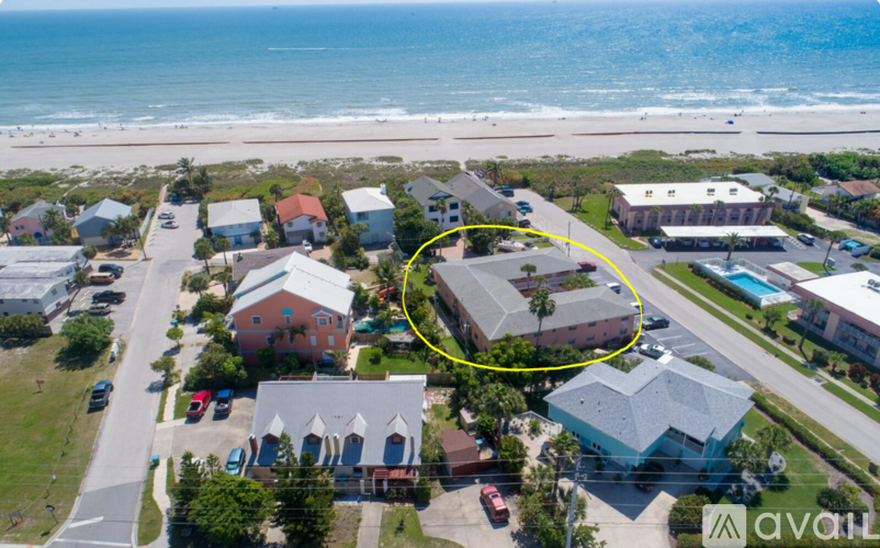 A bird's eye view of a beachfront property with a yellow circle highlighting a specific house.