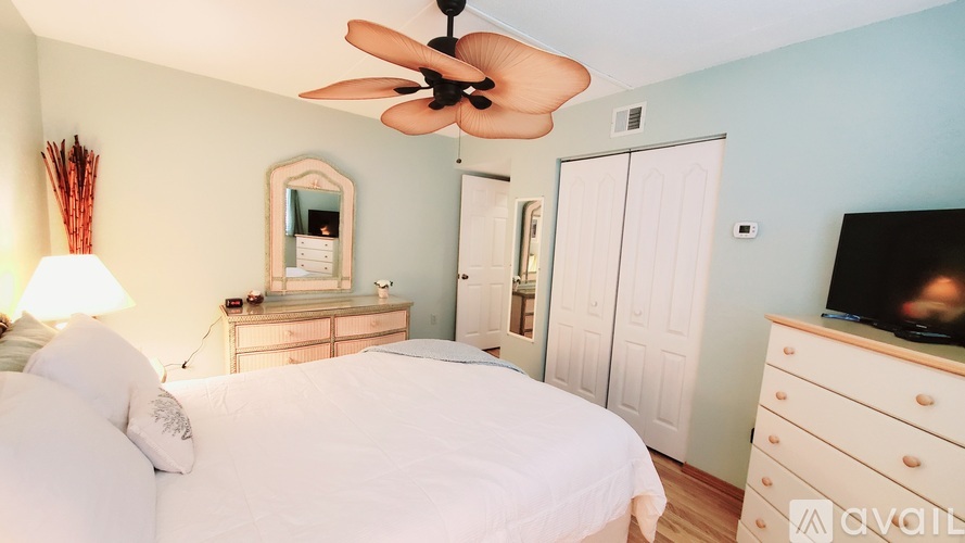 A bedroom with a bed, dresser, and mirror.