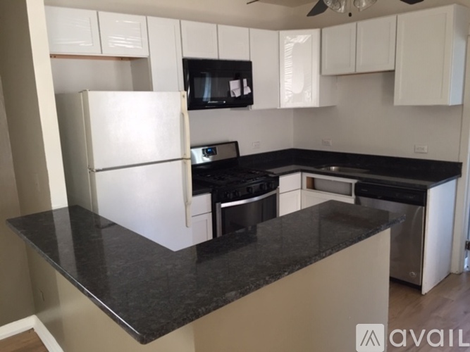 A kitchen with black countertops and white cabinets.