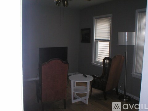 A living room with a chair, a table, and a television.