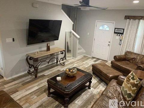 A living room with a brown leather couch and a wooden coffee table.