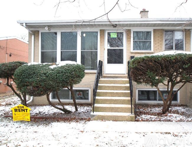 A house with a "For Rent" sign in front of it.