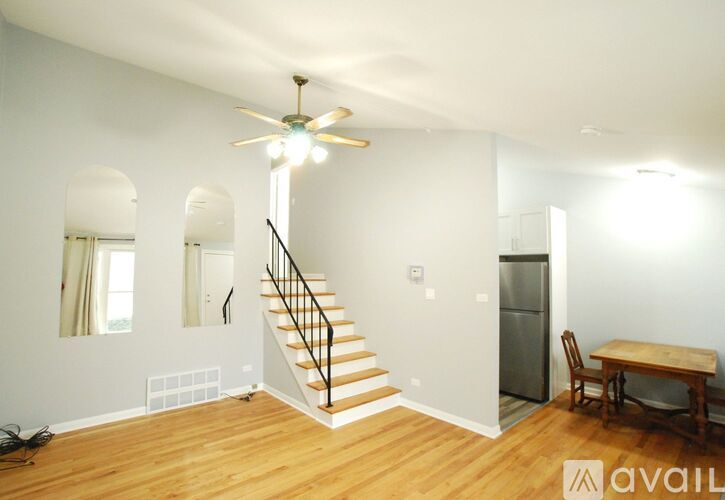 A room with a staircase, a table, and a chair.