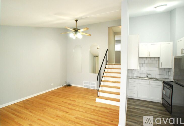 A room with a ceiling fan and wooden flooring.