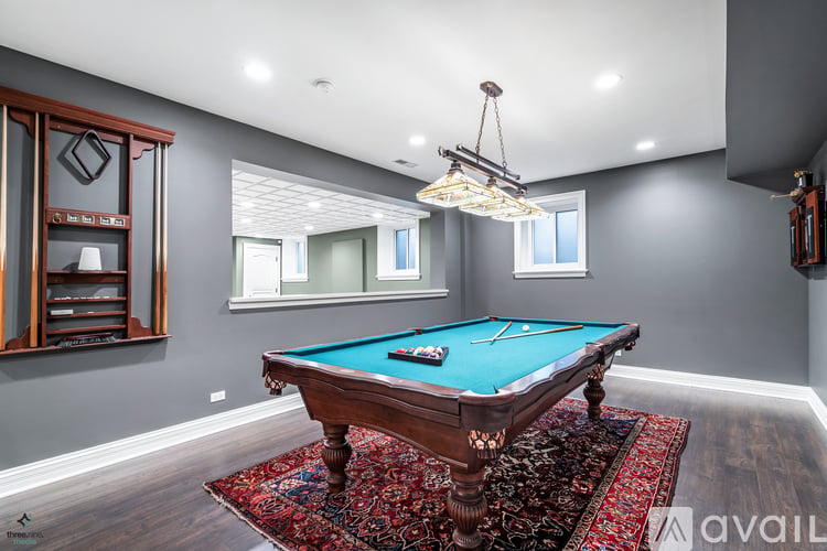 A pool table with a green felt cloth is in the center of the room.