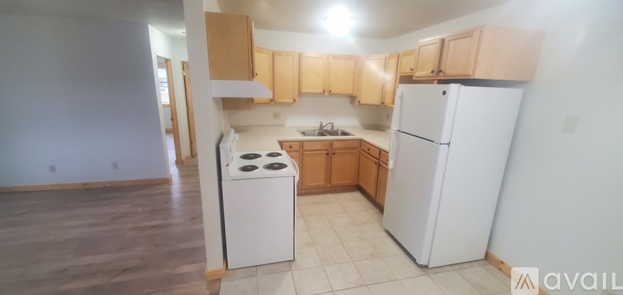 A kitchen with a white refrigerator and a white stove top oven.