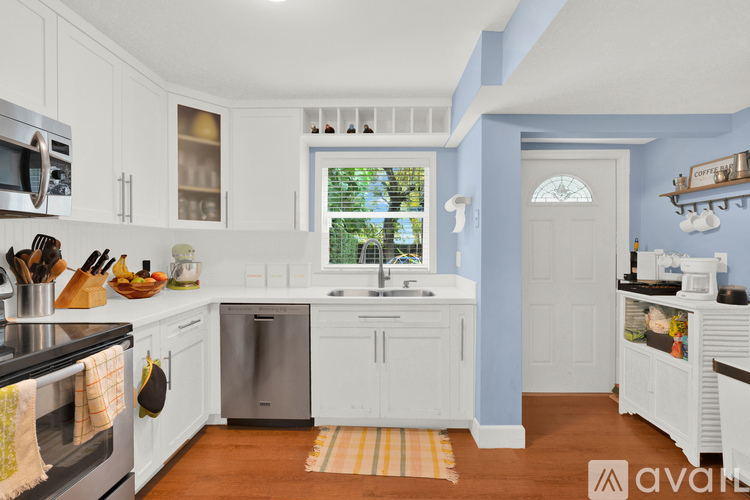 A kitchen with white cabinets and a dishwasher.