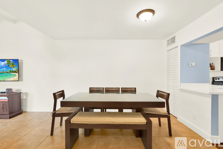 A dining room with a wooden table and chairs.