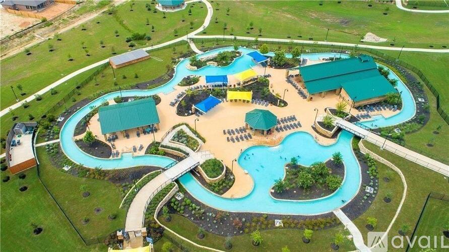 An aerial view of a resort with a large swimming pool and surrounding buildings.